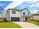 Charming two-story home with black trimmed windows, a well-manicured lawn, an inviting porch, and black garage door at 221 Cobb St, Palmetto, GA 30268