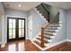 Inviting foyer showcasing hardwood floors, staircase with wooden railings, and natural light from the front doors at 221 Cobb St, Palmetto, GA 30268