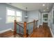 Upstairs hallway features hardwood floors, wrought iron staircase, and view of a bedroom at 221 Cobb St, Palmetto, GA 30268