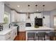 Bright kitchen boasts white cabinets, stainless steel appliances, and an island with barstool seating at 221 Cobb St, Palmetto, GA 30268