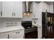 Modern kitchen featuring white cabinets, sleek black hardware, and stainless steel appliances at 221 Cobb St, Palmetto, GA 30268