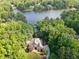 Aerial view of a lakeside home surrounded by lush greenery and other waterfront properties at 210 Lawn Market, Sharpsburg, GA 30277