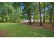 Well-manicured lawn with mature trees leading to a lakefront at 210 Lawn Market, Sharpsburg, GA 30277