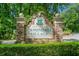 Stone entrance sign for Canongate Village, surrounded by manicured shrubs and trees at 210 Lawn Market, Sharpsburg, GA 30277