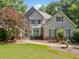 Charming two-story home with manicured lawn, stone accents and mature trees at 210 Lawn Market, Sharpsburg, GA 30277