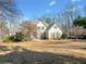 Charming two-story home features a stone-accented facade, well-manicured lawn, and beautiful mature trees on a sunny day at 210 Lawn Market, Sharpsburg, GA 30277