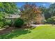 Charming home featuring manicured landscaping, a stone walkway, and mature trees at 210 Lawn Market, Sharpsburg, GA 30277