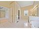 Large main bathroom with soaking tub, double vanity, white tile floors, and a separate toilet room at 210 Lawn Market, Sharpsburg, GA 30277
