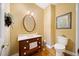 Traditional powder room with dark wood vanity, framed mirror, wall art, and standard toilet at 210 Lawn Market, Sharpsburg, GA 30277