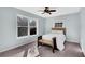 Bright bedroom with a large window, featuring a wood-frame bed, ceiling fan and neutral colored carpet at 4037 Plantation Dr, Marietta, GA 30062