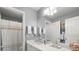 Bright bathroom featuring a white vanity, a neutral shower curtain, and coordinating decorative items throughout at 423 Treetop Cir, Canton, GA 30115