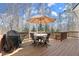 A spacious wooden deck featuring a grill and outdoor dining set, perfect for entertaining at 423 Treetop Cir, Canton, GA 30115