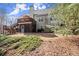 The rear exterior of the home shows a well-maintained lawn and deck, set amongst mature trees at 423 Treetop Cir, Canton, GA 30115