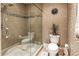 Bathroom with walk-in glass shower, decorative tile and wallpaper, toilet, and neutral color palette at 1050 Carnoustie Ln, Alpharetta, GA 30005