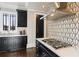 Modern black and white kitchen with stainless steel appliances and marble countertops at 1050 Carnoustie Ln, Alpharetta, GA 30005