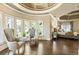 Bright main bedroom with sitting area, hardwood floors, and multiple windows overlooking nature at 1050 Carnoustie Ln, Alpharetta, GA 30005