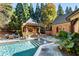 Outdoor pool area with a cabana, a dining area, and beautiful backyard landscaping at 1050 Carnoustie Ln, Alpharetta, GA 30005