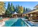 Inviting backyard pool area featuring a pavilion, ample lounge space, and lush greenery for relaxing outdoor enjoyment at 1050 Carnoustie Ln, Alpharetta, GA 30005
