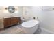 Tranquil bathroom with freestanding tub, wood vanity, and sconces at 2402 Tiffany Cir, Decatur, GA 30035