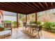 Covered back porch area with a table and chairs surrounded by lush greenery and shrubs at 42 W Belle Isle Ne Rd, Atlanta, GA 30342