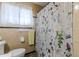 Cozy bathroom with a floral shower curtain, tile walls, and a bright window at 42 W Belle Isle Ne Rd, Atlanta, GA 30342