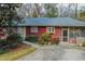 Cozy single-story home featuring a screened porch, mature landscaping, and a concrete driveway at 42 W Belle Isle Ne Rd, Atlanta, GA 30342