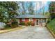 Cozy single-story home featuring a screened porch, mature landscaping, and a concrete driveway at 42 W Belle Isle Ne Rd, Atlanta, GA 30342