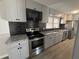 Renovated kitchen featuring gray cabinets, black backsplash, and stainless steel appliances at 536 Joann Ave, Austell, GA 30168