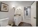 A bathroom with white cabinets, a large mirror, a toilet and wood look tile flooring at 2950 Duke Of Gloucester, Atlanta, GA 30344