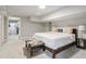 Bedroom with queen bed, bench, and adjacent bathroom entrance, offering comfort and style at 2950 Duke Of Gloucester, Atlanta, GA 30344