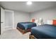 A bedroom features two beds with blue comforters and orange pillows. The room is well-lit at 2950 Duke Of Gloucester, Atlanta, GA 30344