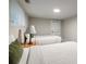 A well lit bedroom features twin beds with neutral bedding and a view of the backyard at 2950 Duke Of Gloucester, Atlanta, GA 30344