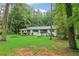 Serene home exterior with a verdant lawn surrounded by towering trees, blending nature and comfort at 2950 Duke Of Gloucester, Atlanta, GA 30344
