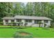 Inviting single-Gathering home showcasing a lush green lawn, manicured bushes, and a welcoming front porch at 2950 Duke Of Gloucester, Atlanta, GA 30344