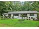 Attractive home surrounded by mature trees, a lush green lawn, and decorative shrubbery adding curb appeal at 2950 Duke Of Gloucester, Atlanta, GA 30344