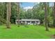 Scenic view of home nestled among tall trees, a sprawling green lawn, and natural landscaping at 2950 Duke Of Gloucester, Atlanta, GA 30344