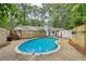 Backyard with a kidney-shaped pool, concrete surround, privacy fence, and mature trees at 2950 Duke Of Gloucester, Atlanta, GA 30344