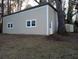 Detached garage with neutral siding, traditional roll up door, side door, and multiple windows at 9031 Thornton Rd, Jonesboro, GA 30236