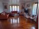 Sun-filled living room with glossy hardwood floors and eclectic furniture at 9031 Thornton Rd, Jonesboro, GA 30236