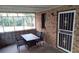 Enclosed porch featuring a brick wall, decorative screen door, table and chairs at 9031 Thornton Rd, Jonesboro, GA 30236