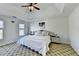 Spacious bedroom featuring a tray ceiling with ceiling fan, a comfortable bed, and a window view at 420 Woodbrook Way, Lawrenceville, GA 30043