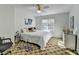 Bright bedroom featuring a ceiling fan, patterned carpet, and a comfortable bed with white bedding at 420 Woodbrook Way, Lawrenceville, GA 30043