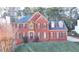 Two-story brick home with a blue roof, dormer windows, and manicured front lawn at 420 Woodbrook Way, Lawrenceville, GA 30043