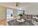 Living room with hardwood floors, a gray sectional, and an open entryway to a sunroom at 420 Woodbrook Way, Lawrenceville, GA 30043