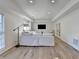 Bright living room with white sofa, wood flooring, and a wall-mounted television at 420 Woodbrook Way, Lawrenceville, GA 30043
