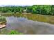 This pond scene features a lush landscape with a nearby dock and hints of houses tucked into the forest at 420 Woodbrook Way, Lawrenceville, GA 30043