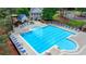 A community pool, surrounded by trees and lounge chairs, offers swimming with a large pool and a playground at 420 Woodbrook Way, Lawrenceville, GA 30043