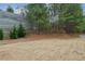 A gently sloping, grass-covered back yard with a mix of mature pine trees and newly planted trees is seen at 4662 Creekside Villas Se Way, Smyrna, GA 30082