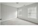 A bright bedroom featuring neutral walls, carpet, and windows with blinds, offering a serene living space at 4662 Creekside Villas Se Way, Smyrna, GA 30082