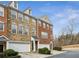 Brick townhouse with attached garages, trimmed bushes and front door entry, on a sunny day with blue skies at 4662 Creekside Villas Se Way, Smyrna, GA 30082